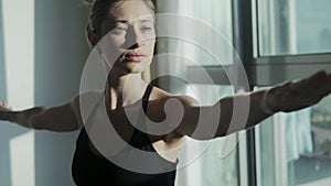 Young woman practicing yoga at home with cityscape background