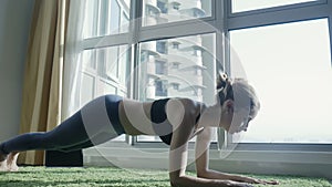 Young woman practicing yoga at home with cityscape background