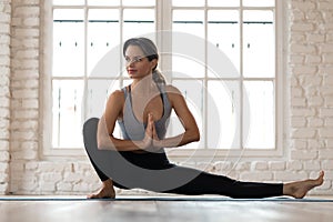 Young woman practicing yoga, Janu Sirsasana pose