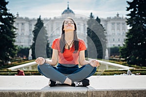 Young woman practicing yoga and meditation in park.Urban relaxation. Female meditating in a public park.Morning routine.Stress