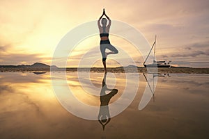 Young woman practicing yoga in the nature, Female happiness, Silhouette of young woman practicing yoga on the beach at sunset