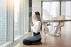 Young woman practicing yoga in the office