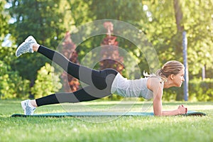 Young woman practicing yoga outdoors at the park