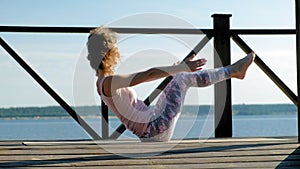 Young woman practicing yoga outdoors in summer. Healthy lifestyle