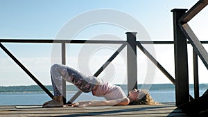 Young woman practicing yoga outdoors in summer. Healthy lifestyle