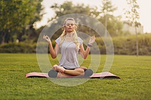 Young Woman practicing yoga pose at the city park at sunset - Concept for Yoga Sport and Healthy lifestyle