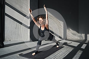 Young woman practicing yoga poses in an urban background on sunny day