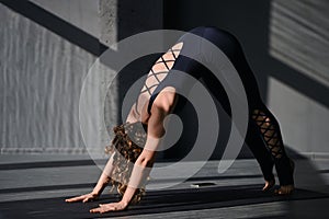 Young woman practicing yoga poses in an urban background on sunny day