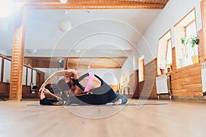 Young woman practicing yoga, stretching in variation of Reverse Table Top exercise, Bridge pose, working out, wearing