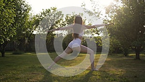 Young woman practicing yoga at sunrise in the garden