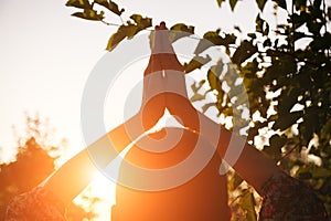 young woman practicing yoga at sunset