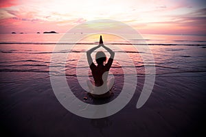 Young woman practicing yoga at sunset