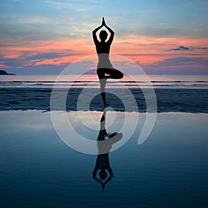 Young woman practicing yoga at sunset on the coast