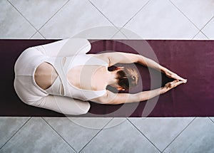 Young woman practicing yoga on yoga mat indoors