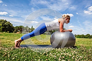 Young woman practising gym on a sports ball