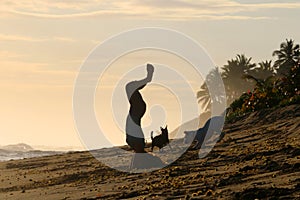 Young woman practising yoga on the beach