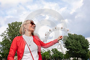 Young woman in the Prater area on the background of the Vienna Ferris Wheel