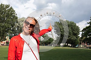 Young woman in the Prater area on the background of the Vienna Ferris Wheel