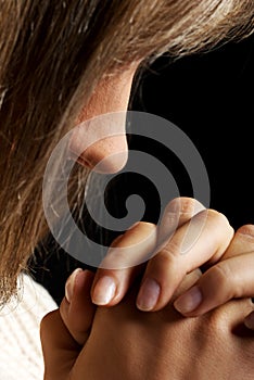 Young woman praying, close up.
