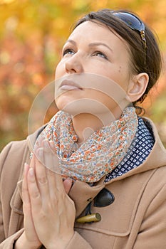 Portrait of young woman praying in park