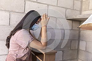 Young woman praying with face mask with face masks