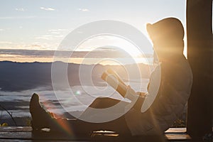 Young woman praying With the Holy Bible in the morning, Woman praying with hands together on the Sunrise background