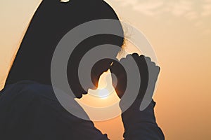 Young woman praying in the morning, Hands folded in prayer concept for faith, spirituality and religion photo