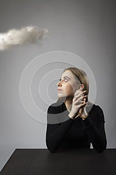 Young woman is praying with rosary beads and cloud