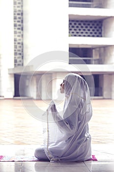 Young woman praying to Allah in the mosque