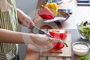 A young woman prepares bell peppers for her breakfast and is ready for a healthy meal on the table with healthy, organic