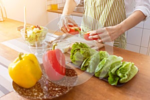 A young woman prepares bell peppers for her breakfast and is ready for a healthy meal on the table with healthy, organic