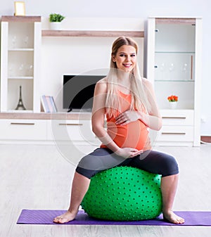 Young woman preparing for birth exercising at home