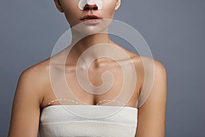 Young woman preparing for breast augmentation and wearing white towel