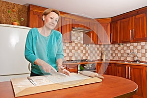 Young woman preparing dough in kitchen