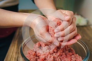 Young woman preparing ground beef for hamburgers