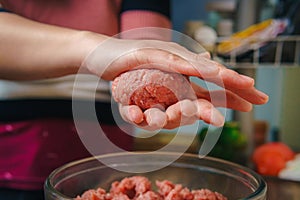 Young woman preparing ground beef for hamburgers