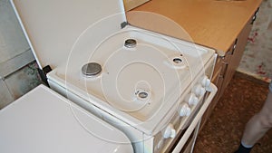 Young woman preparing stove for cleaning