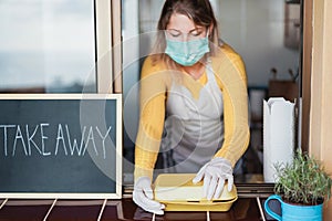Young woman preparing take away fast food during coronavirus outbreak - Focus on hands