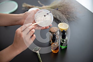 Young woman preparing white clay for mask