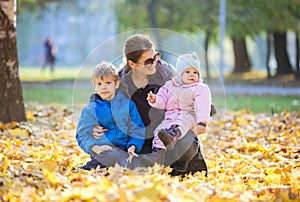Young woman with preschool son and baby daugther enjoying beautiful day photo