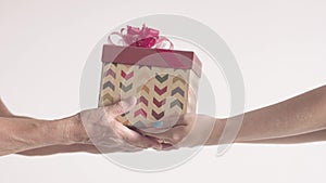 Young Woman present gift box in older woman`s hands. Happy Retired grandmother getting christmas by old hands.
