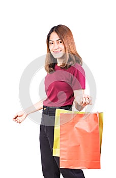 Young woman pretty smiling holding paper bags green and orange shopping. on white background and looking at camera