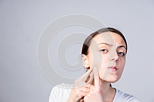 Young Woman Pricking Blackheads on her Cheek photo