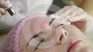 Young woman with problem skin getting a cosmetic procedures with medical equipment