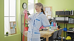 Young woman professional cleaner cleaning floor suffering backache at the office