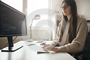 Young woman programming at her home office