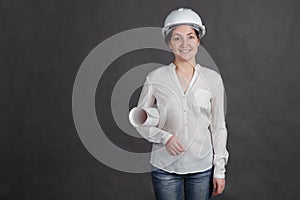 Young woman in protective helmet with paper in hands