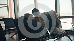 A young woman in a protective mask sleeping at the airport lounge