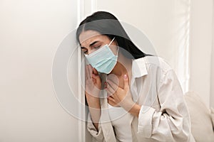 Young woman with protective mask suffering from breathing problem at home