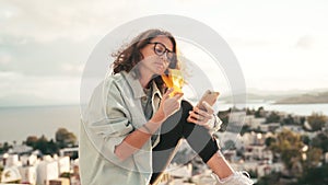 A young woman in protective mask unlocks her smartphone with a face id